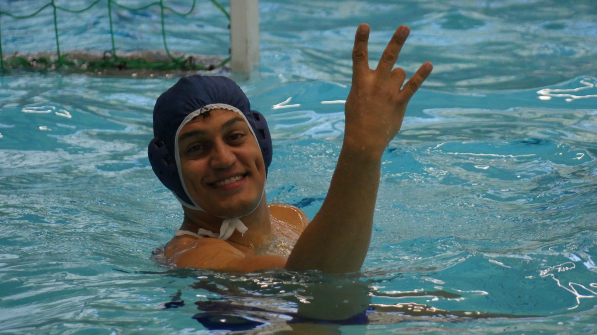 Player smiling and waving in the pool after training